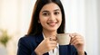 © shahinahmed - Woman in blue blazer smiling and holding a coffee cup on white background
