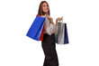 © Komora - Woman smiling, holding colorful shopping bags after successful retail therapy, enjoying shopping experience