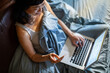 © Davor - Woman shopping online with credit card in bed at home