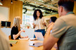 © we.bond.creations - Multicultural business professional leading a team meeting, discussing ideas and collaborating in a contemporary office workspace