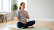 © Xenia - Pregnant woman meditating on a yoga mat with hands on chest and belly. Expectant mother practicing breathing exercises at home. Healthy pregnancy wellness