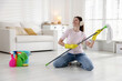 © New Africa - Spring cleaning. Happy woman having fun and tidying up floor with mop at home