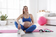 © New Africa - Pregnant woman in sportswear on fitness mat at home