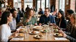 © Максим Новосветлов - Multiethnic colleagues enjoying a business lunch at a large wooden table in a bright, modern restaurant with various dishes.