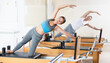 © JackF - Female athletic woman doing stretching on pilates machine in pilates studio