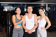 © JackF - Man and two girls are standing in gym and relaxing. Coaching staff of gym. Team of athletes in sportswear stands in fitness center