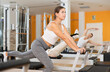 © JackF - Girl gym visitor performs reformer exercises aimed at stretching leg muscles and strengthening muscles of lower extremities. Pilates equipment in gym, classes for athletes and amateurs