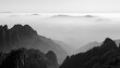 © Travel 'n' Lifestyle - View of the misty peaks and sea of clouds at Huangshan with pine trees and jagged rock formations in black and white Huangshan City, Anhui, China.