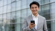 © 伦 蔡 - Man in suit holding smartphone outdoors