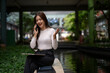 © Apichat - Happy business woman talking on smartphone outdoors