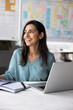 © fizkes - Happy professional woman sits at desk with open laptop holding documents, review data, feel satisfied with project progress, sales growth, take break, thinks on perspectives, career and opportunities