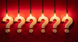 © Delara - Six illuminated question mark symbols hanging in a row against a red wall with question solution background conceptual