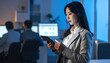© kinara - Focused Young Businesswoman Using Tablet in Modern Office at Night