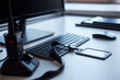 © DragonImages - Close up of office desk showing keyboard, monitor, radio handset, access card, smartphone and headset, presenting workplace communication and security tools for IT support or operations