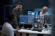 © DragonImages - Multiethnic business team reviewing cybersecurity data on monitors, discussing network analysis in office. Ideal for IT operations, threat detection, digital security marketing
