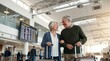 © Iuliia - Senior woman and senior man walking in airport terminal with luggage. Happy elderly couple traveling together before flight. Retirement lifestyle and journey abroad concept, tourism.