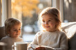 © burntime555 - Two adorable toddlers, siblings, enjoy a cozy moment together by a sunlit window