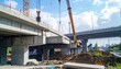 © yai - Construction of elevated highway bridge with crane lifting concrete segment.