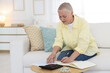 © New Africa - Pension. Senior woman with paperwork, money and calculator at table indoors. Space for text