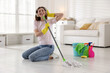© New Africa - Spring cleaning. Happy woman having fun and tidying up floor with mop at home