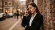 © LorelEino - Woman in suit leaning against brick wall