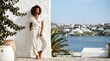 © Bane - Elegant woman posing in white linen jumpsuit against a seaside wall