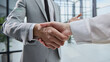 © ASDF - Two professionals shake hands in a modern office