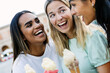 © Xavier Lorenzo - Happy multiracial friends holding ice cream cones outdoors. Young women celebrating friendship while traveling in summer. Lifestyle and vacation concept.