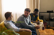 © DragonImages - Multiethnic young adult and middle aged men sitting together, talking and listening during support meeting, expressing trust and male friendship. For counseling, community, mental health campaigns