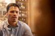 © chandlervid85 - Serious young man talking during dinner date at cozy restaurant