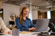 © Rido - Happy customer service woman on call whiel workiong on laptop