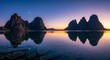 © Platon - Majestic jagged mountains and rocky peaks overlooking a crystal-clear lake during a vibrant golden purple sunrise. The mountain silhouette creates a flawless reflection on the transparent water
