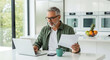© 121icons - man working on laptop with document in modern kitchen interior high quality professional