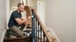 © Xenia - Man painting stair railing. Home renovation project. DIY repair concept
