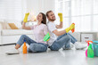 © New Africa - Spring cleaning. Happy couple with detergents sitting on floor at home