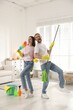 © New Africa - Spring cleaning. Happy couple having fun and tidying up room together at home