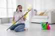 © New Africa - Spring cleaning. Happy woman having fun and tidying up floor with mop at home