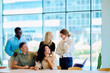 © we.bond.creations - Group of happy multiracial business people discussing work during a meeting, showing teamwork and positive corporate culture