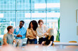 © we.bond.creations - Diverse business professionals smiling and talking during an informal meeting, reflecting teamwork, collaboration, and modern workplace communication