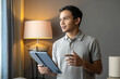 © Ibenk.88 - Asian Man Presenting Information on Tablet During Online Meeting