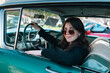 © Dmytro Sharapov - Berlin, Germany - May 2, 2026. Woman posing in classic car at Oldtimer Open Air