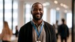 © Thares2020 - A smiling professional man wearing a lanyard stands in a bright modern office setting with large