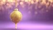 © ahmad - Glittering golden sphere ornament hangs against a purple background with warm light bokeh