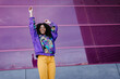 © VISTA by Westend61 - Young woman with urban look cheering in front of pink glass wall