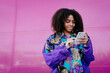 © VISTA by Westend61 - Young woman typing on smartphone and listening to music