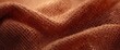 © vxnaghiyev - detailed terracotta textile texture with soft lighting and copy space