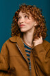 © LIGHTFIELD STUDIOS - Young fashionable woman showcasing a stylish look with curly hair against a vibrant backdrop