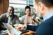 © Marko Geber - Smiling clients meeting with financial advisor at cafe