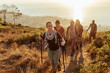 © Marko Geber - Group of friends hiking coastal trail at sunset