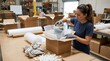 © albari - Female worker packing a ceramic vase into a cardboard box in warehouse